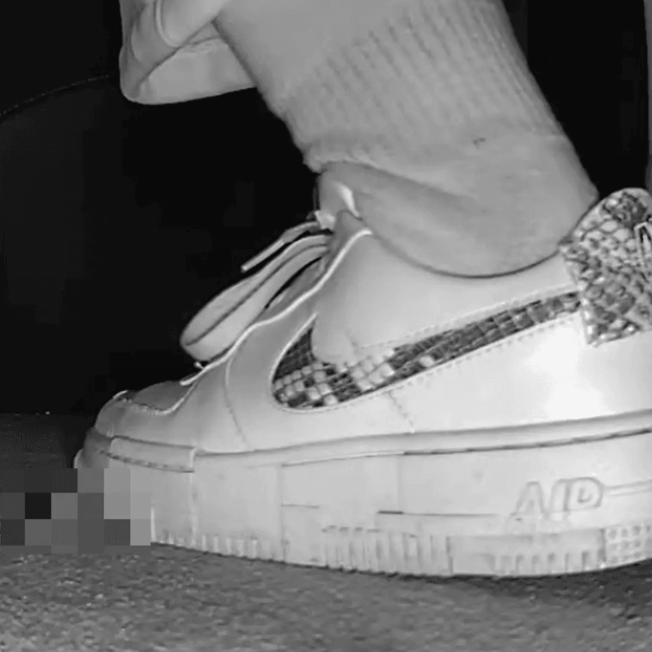 Woman in cinema candid crushing with Nike sneaker